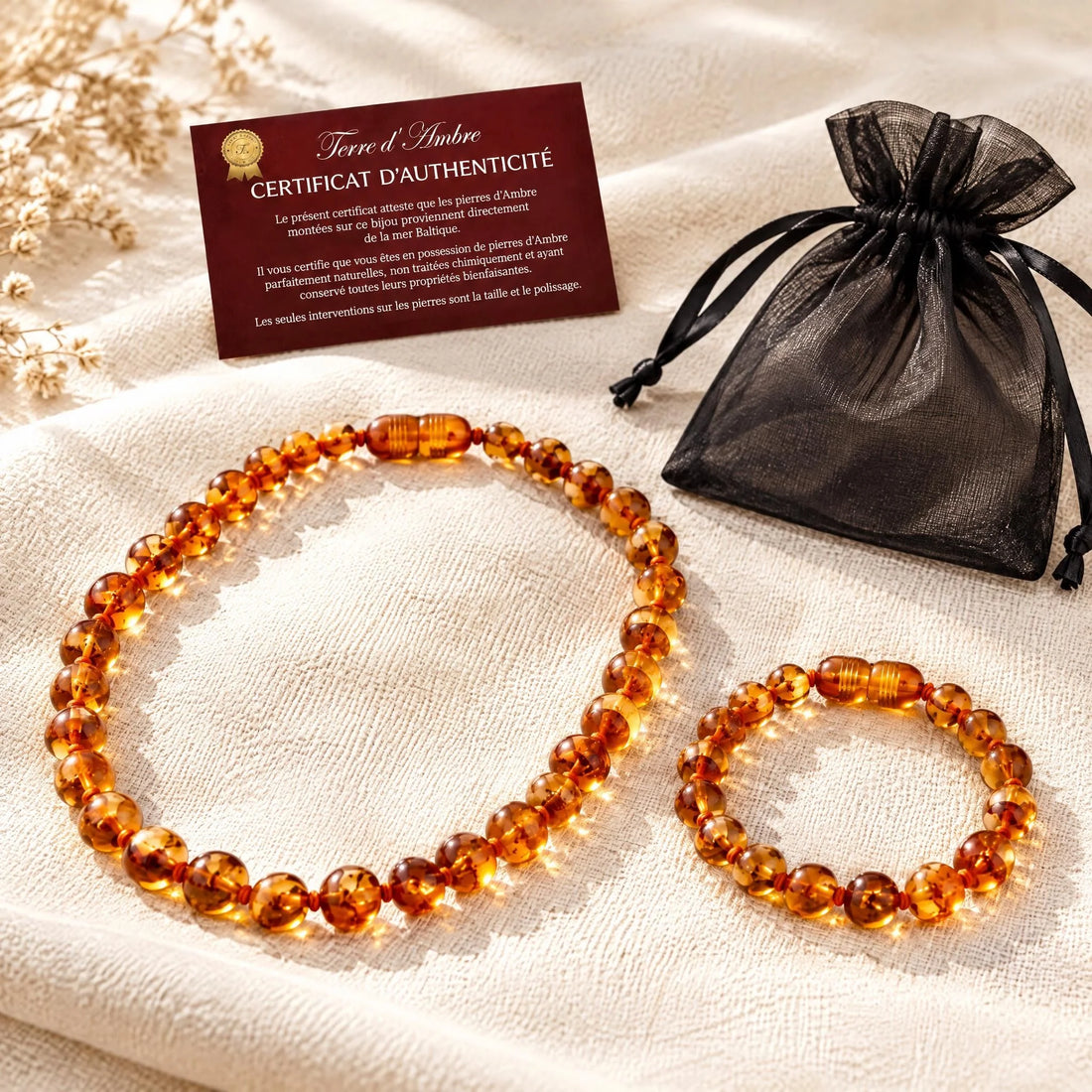 Duo collier et bracelet ambre bébé baroque cognac portés par un bébé | Terre d'Ambre