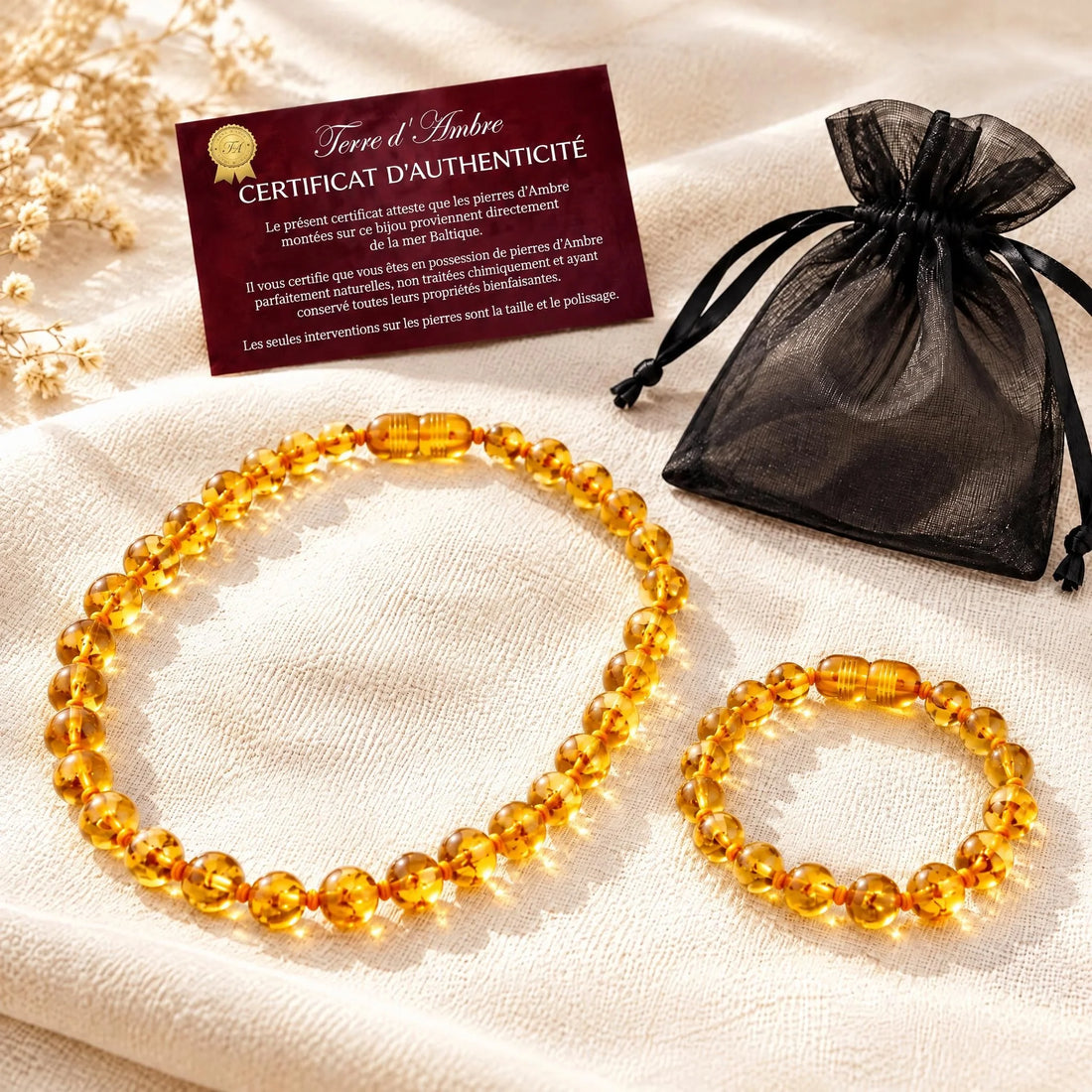 Duo collier et bracelet ambre bébé baroque miel portés par un bébé | Terre d'Ambre