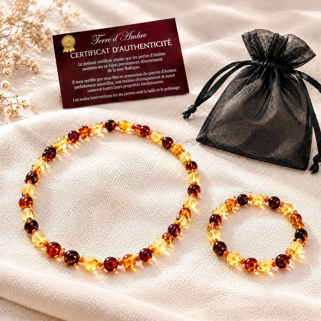 Duo collier et bracelet ambre bébé baroque multicolore portés par un bébé | Terre d'Ambre